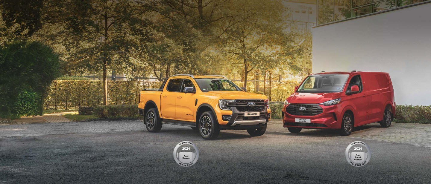 Orange Ford Ranger 3/4 front view on gravel in front of White Ford Ranger 3/4 rear view