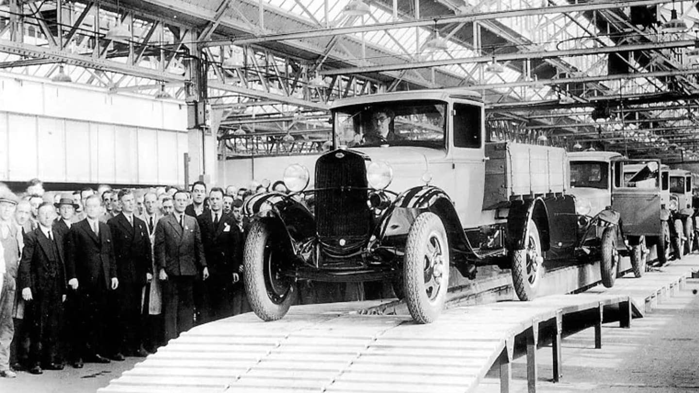 ford factory workers watching ford vehicle roll off the production line