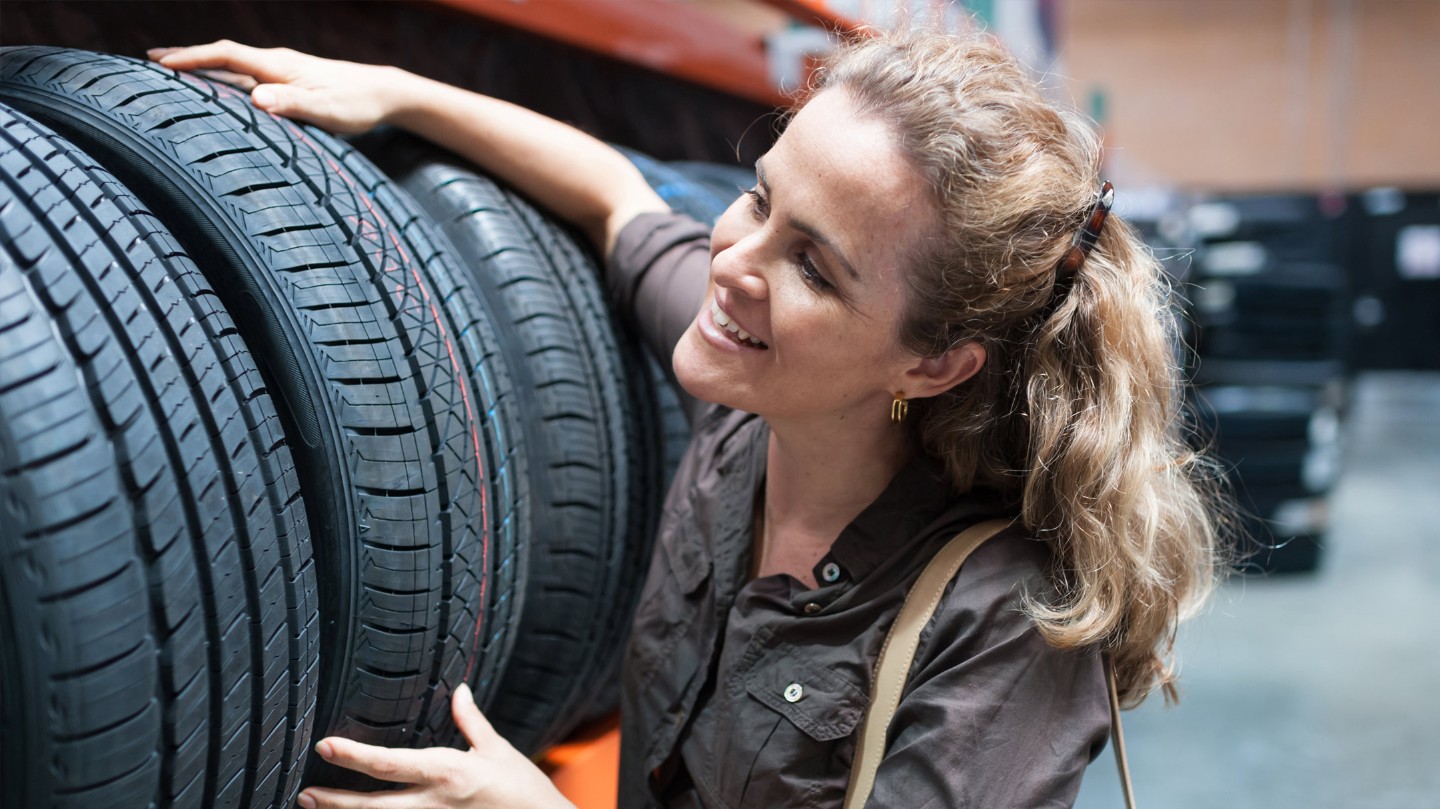 The girl puts the tires on the shelf