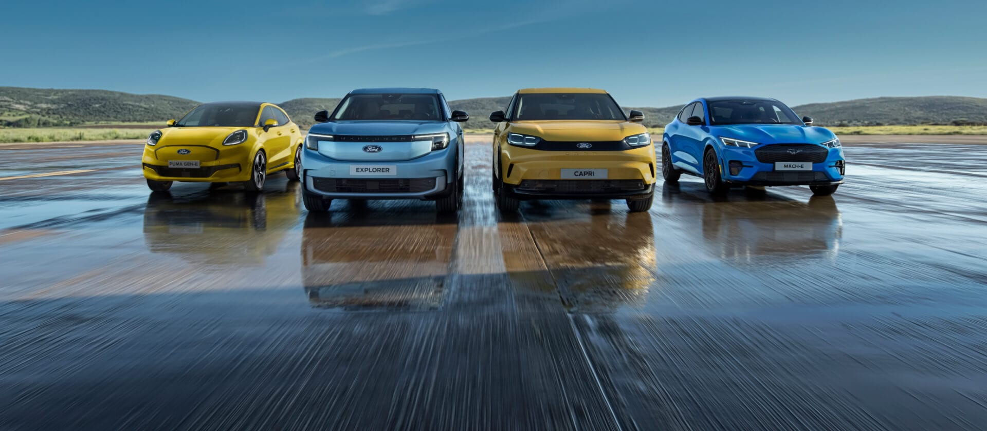 A line-up of the range of Ford electric cars, with the Ford Puma Gen-E, Ford Explorer, Ford Capri and Ford Mustang Mach-E.