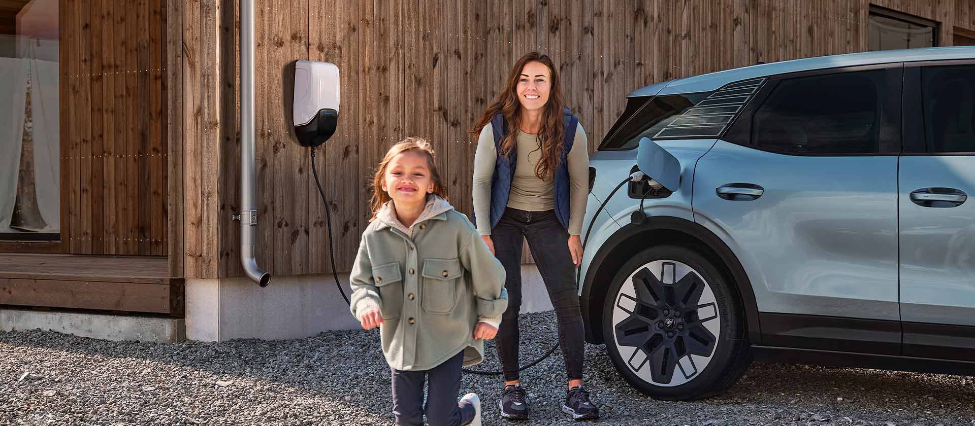 A family having fun while charging their electric Ford Explorer with an outdoor EV home charger.