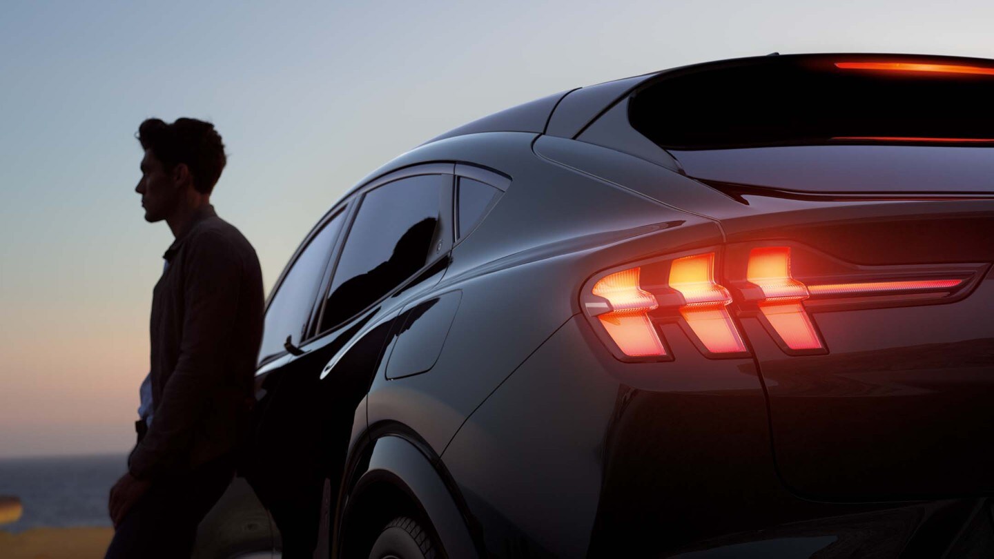 Man standing next to Ford at sunset