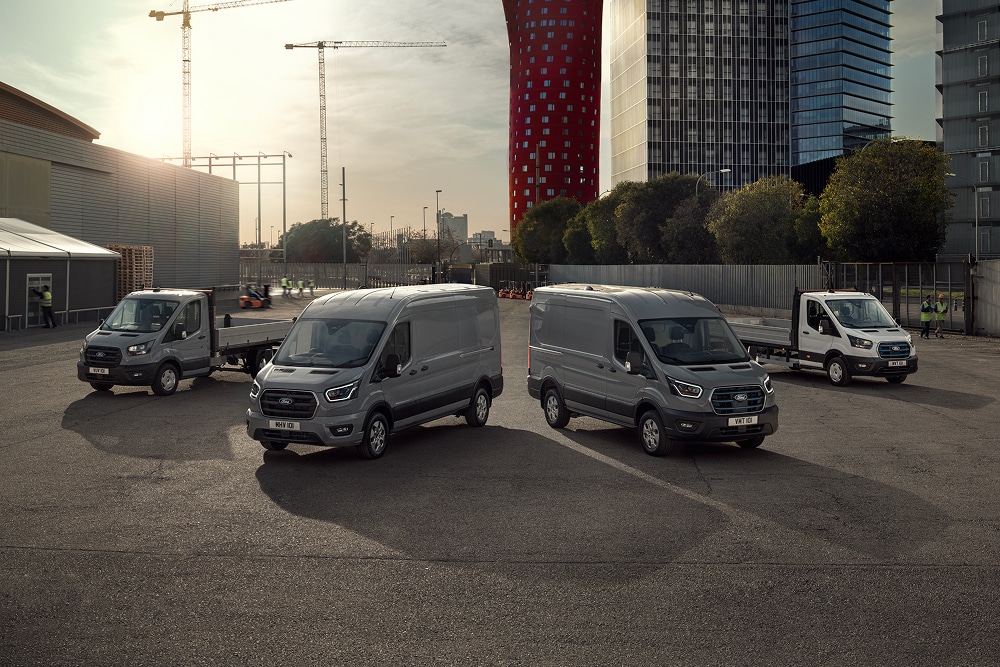 The range of Ford electric and plug-in hybrid vans parked outside in a carpark.