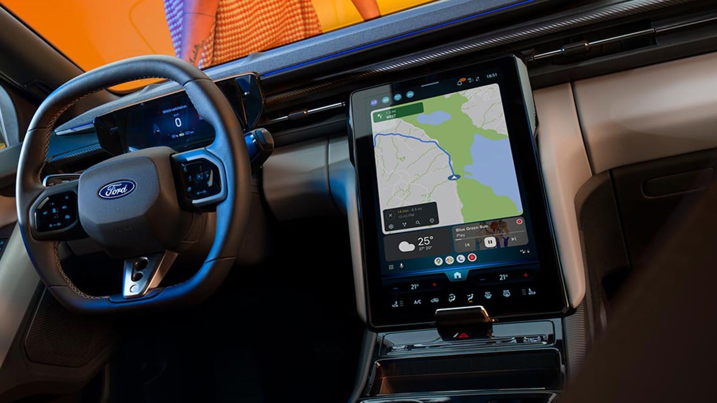 The interior of the all-electric Ford Capri showing the steering wheel and SYNC Move touchscreen.