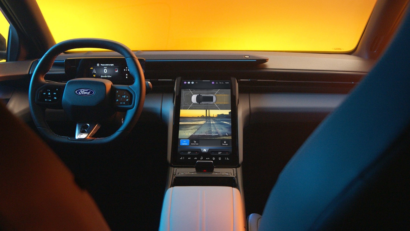 The interior of the all-electric Ford Capri showing the steering wheel and SYNC Move touchscreen.