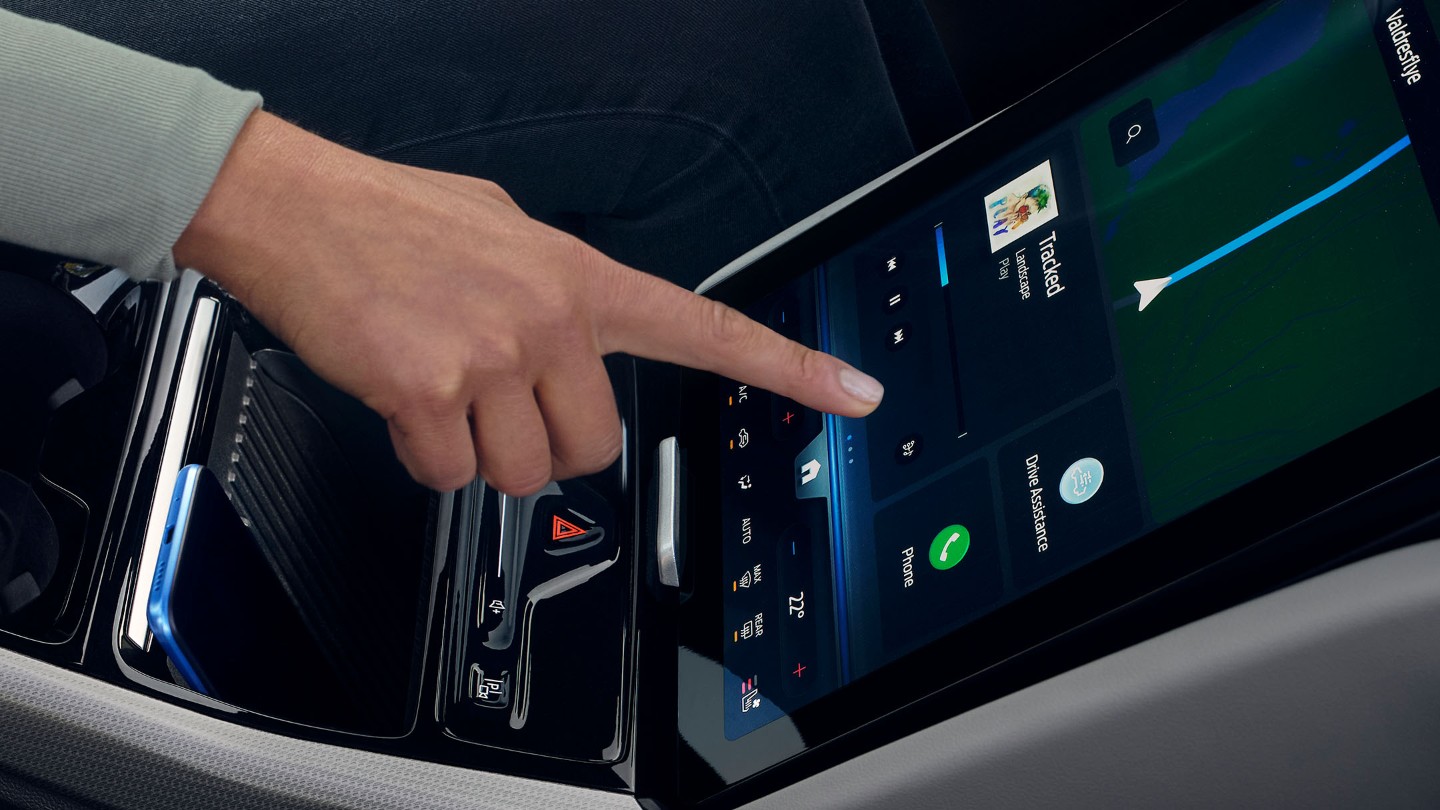 A woman interacting with the large SYNC touchscreen in the Ford Explorer. 
