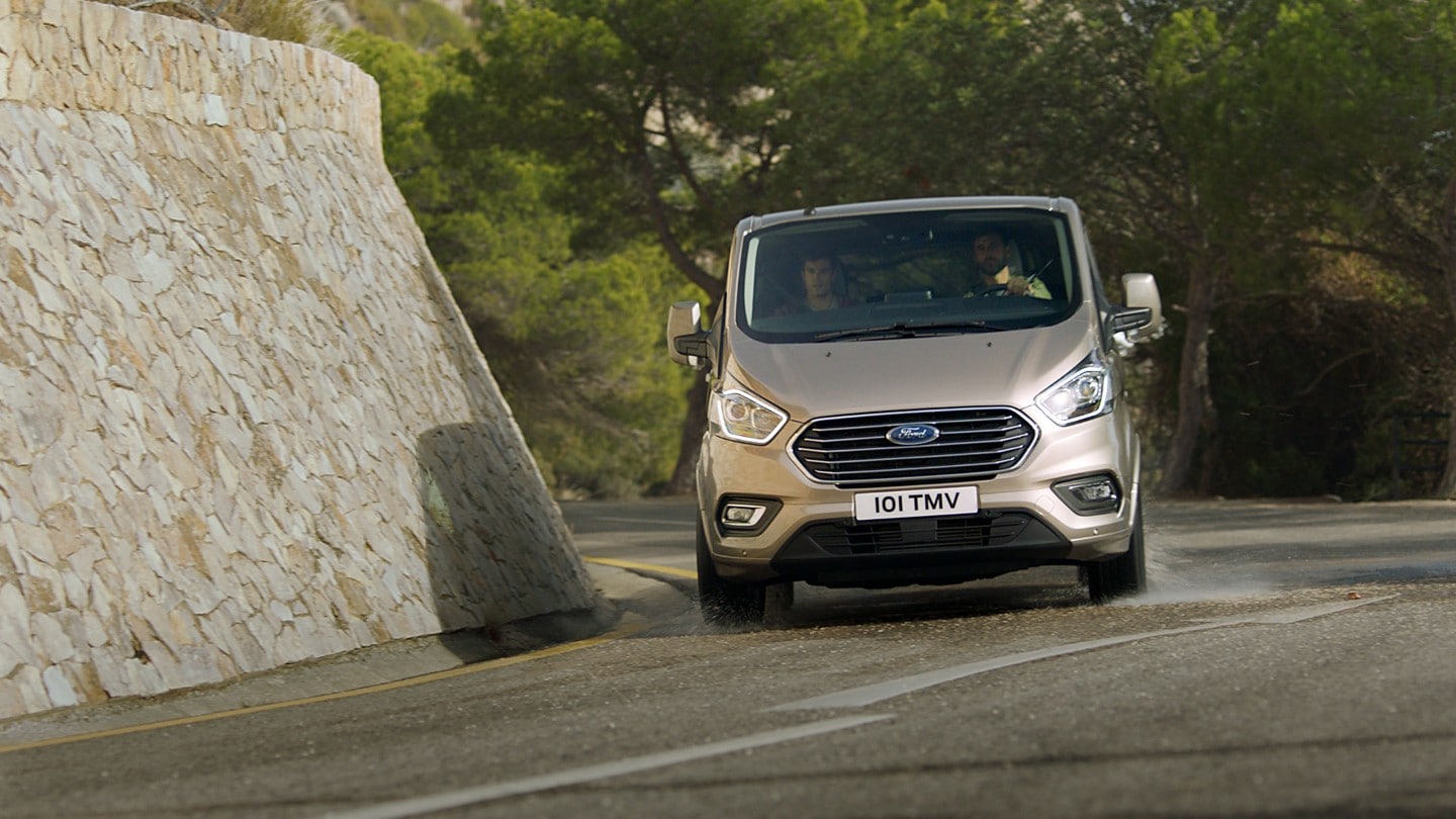 Ford Tourneo Custom driving past rock wall