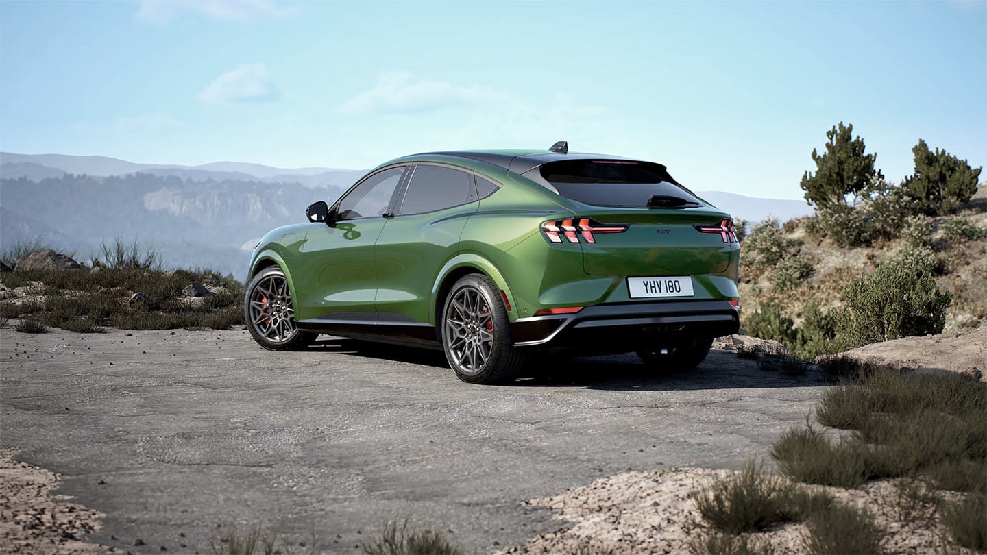 The rear of the Ford Mustang Mach-E GT in Eruption Green parked on a mountain road.