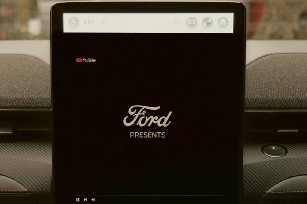 A close up of the 15.5" SYNC 4 touchscreen with a graphic that says "Ford presents", demonstrating the in-car video streaming