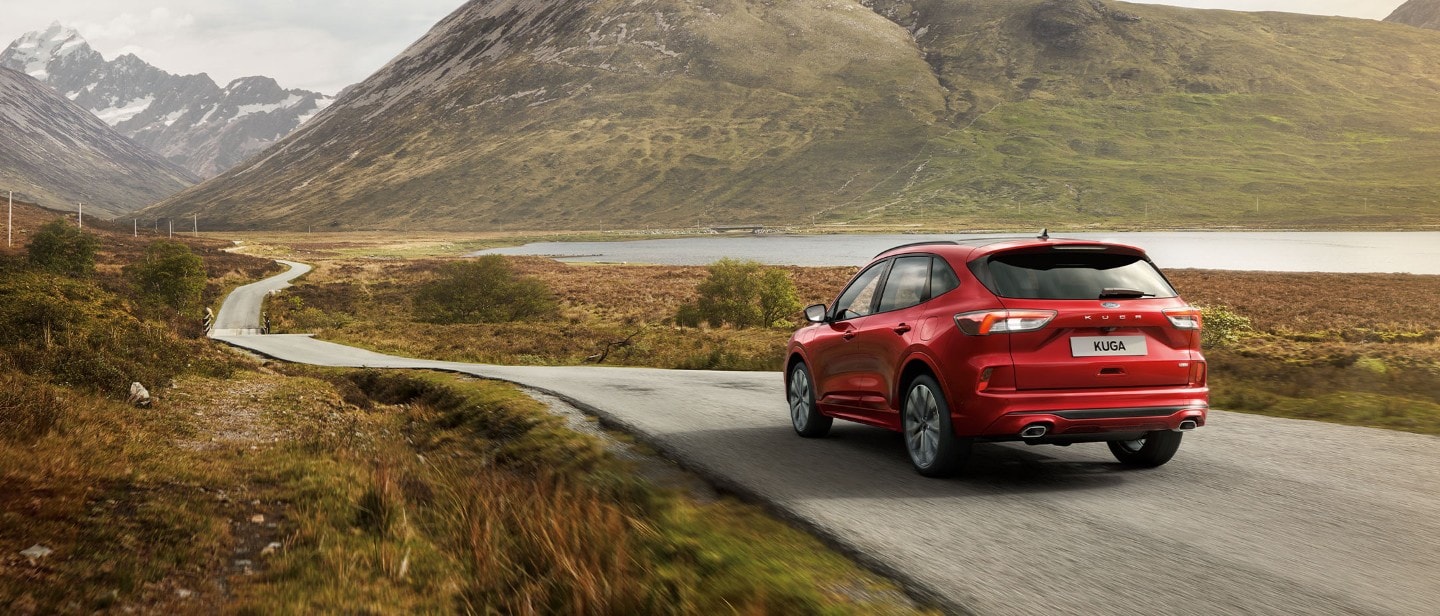 Ruby Red Ford Kuga driving a road in highlands