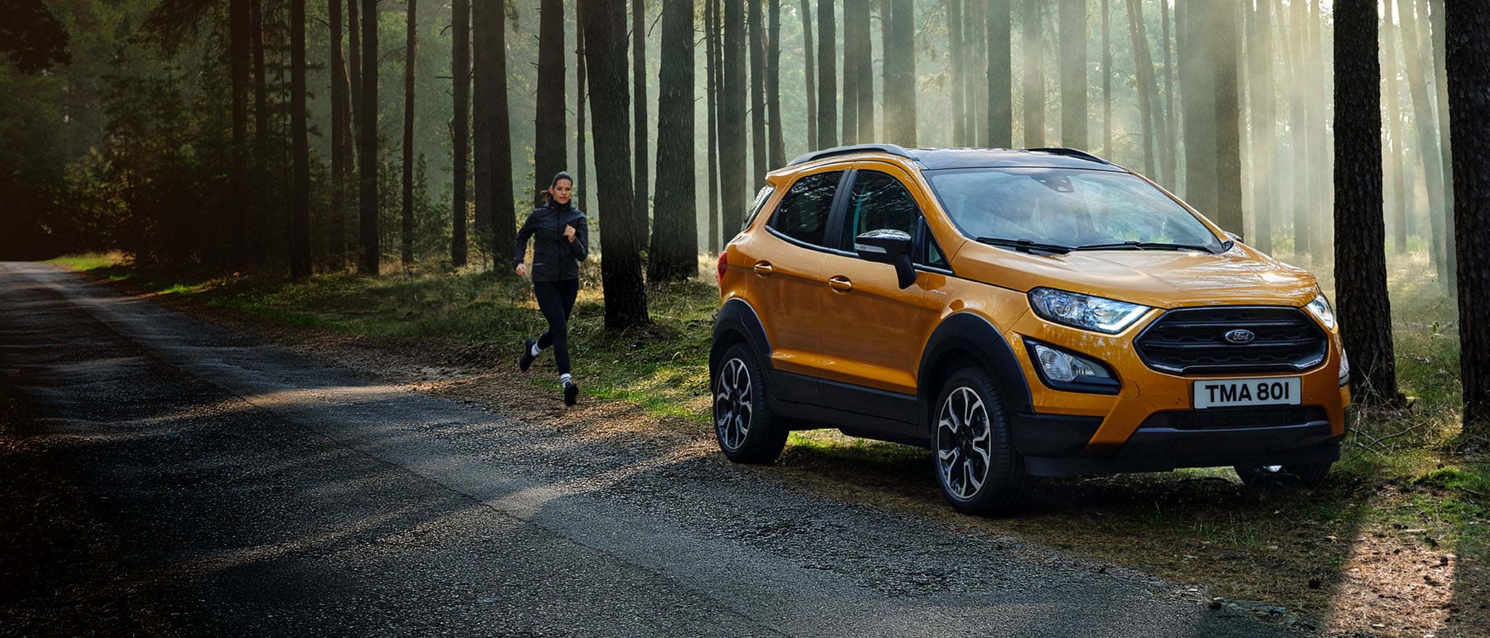 Orange Ford EcoSport parked in the forest