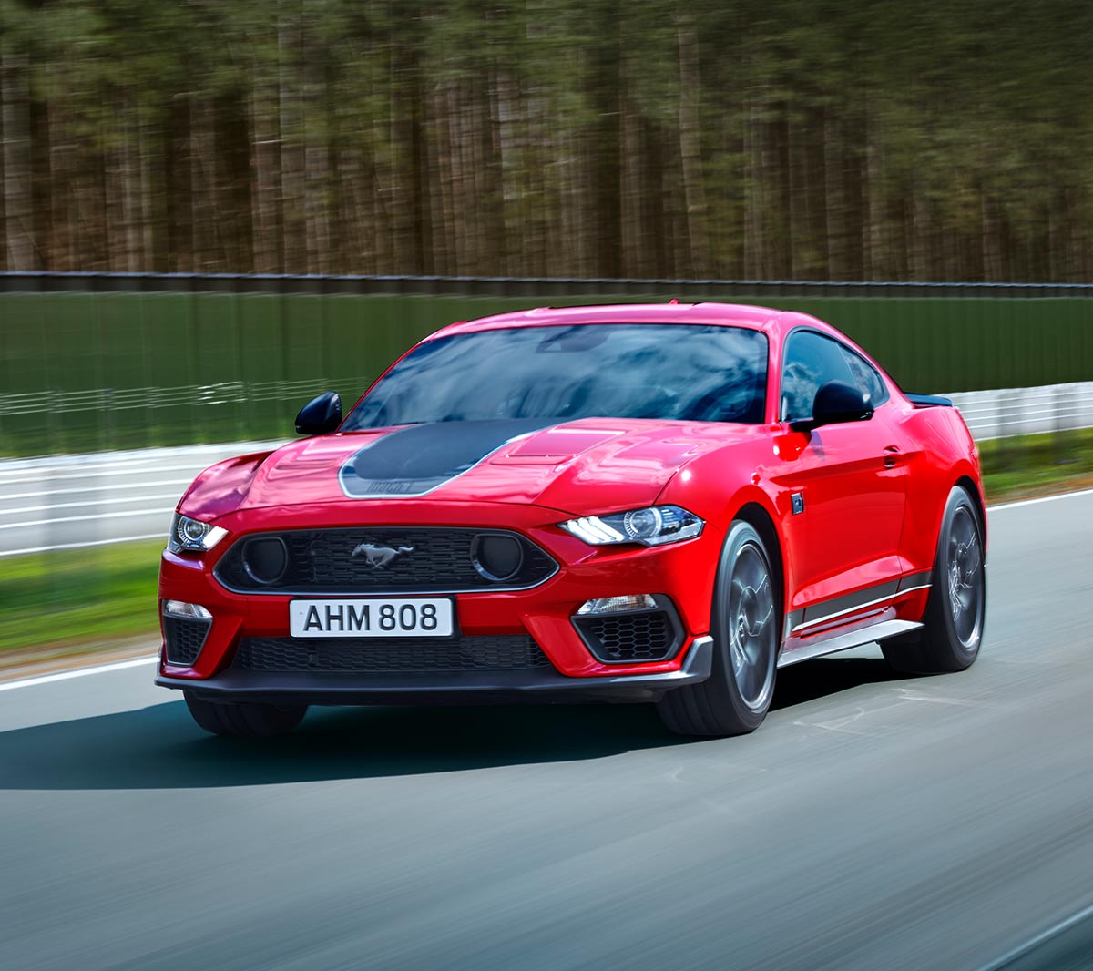 Ford Mustang Mach 1 driving on a racetrack