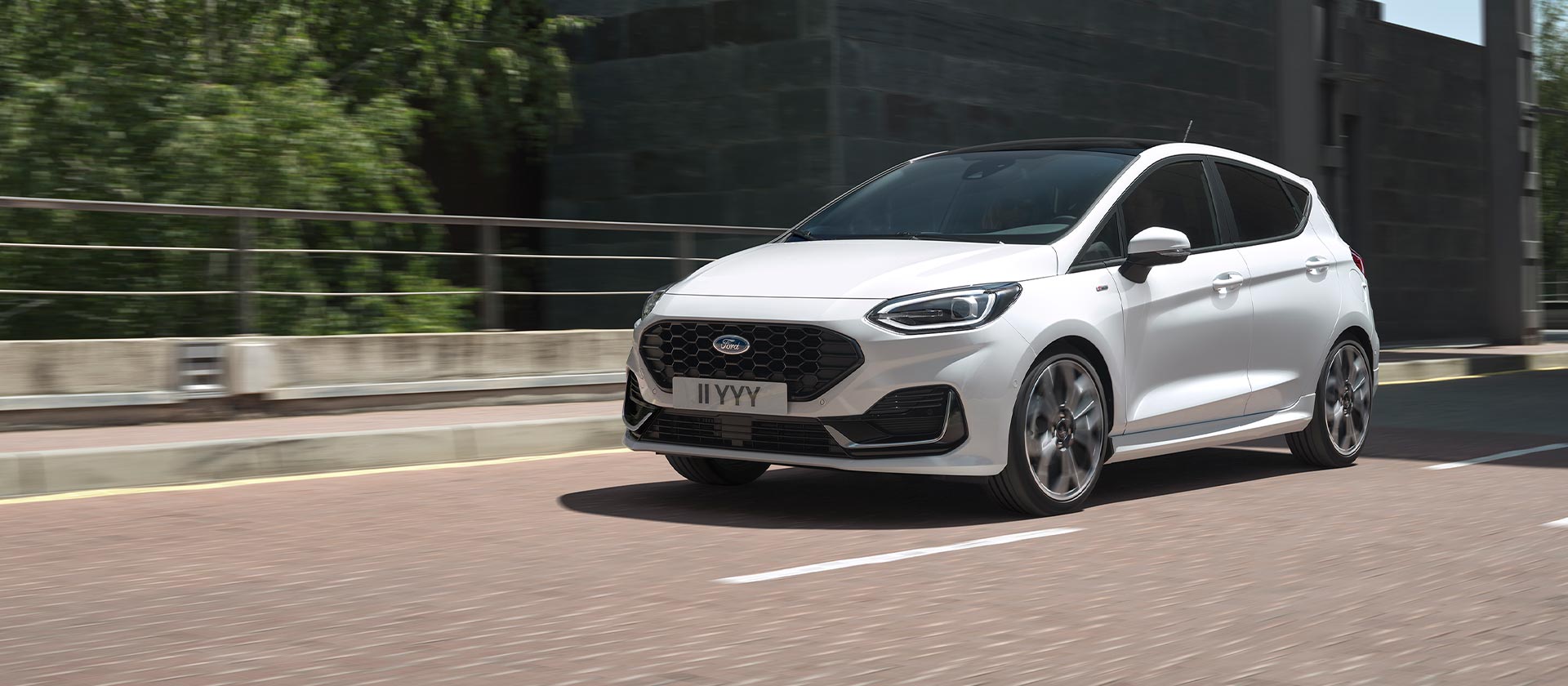 White Ford Fiesta driving in a city