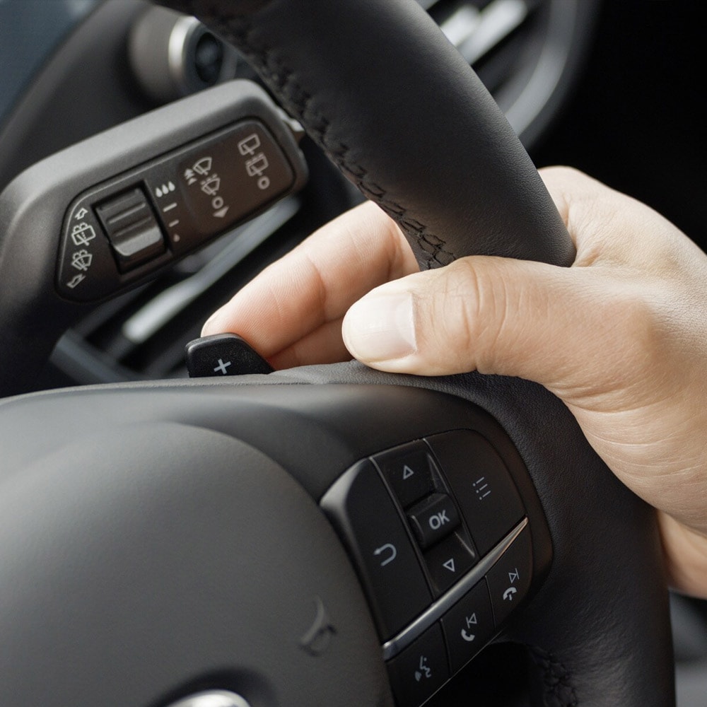 A close-up of a hand operating the Ford Focus paddle gear shifters behind the steering wheel.