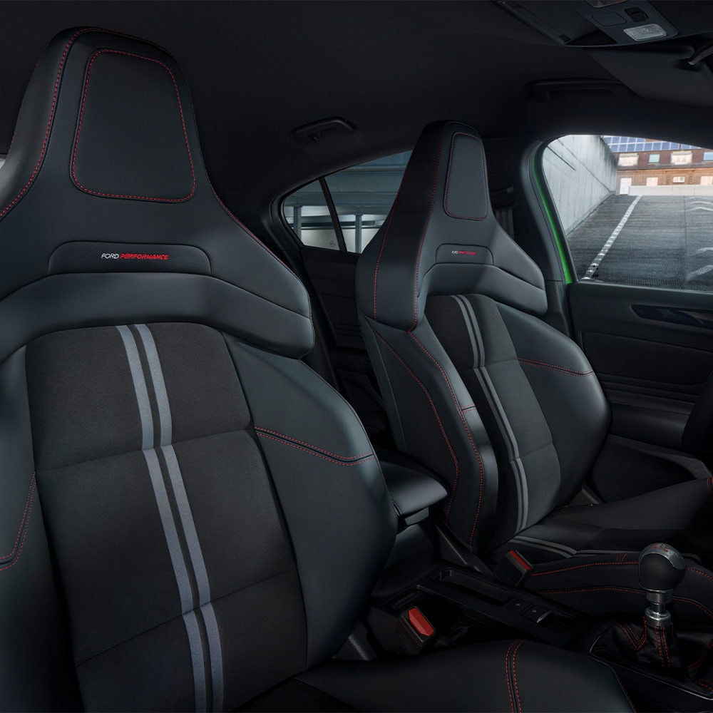 A close up of the Ford Focus ST sports seats, featuring dark upholstery with red contrast stitching.