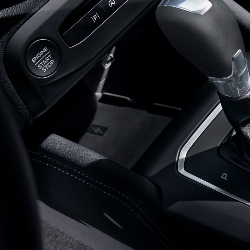 A close-up of a Ford Focus interior showing the wireless phone charger behind the gear selector.