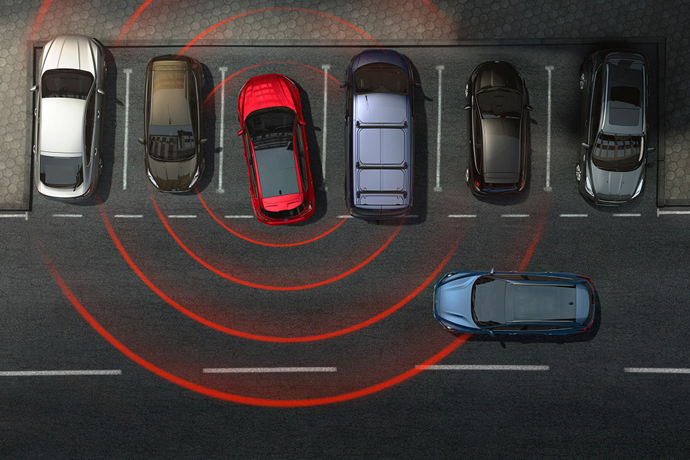 Graphic showing a Ford car reversing out of a parking space, with the cross traffic alert active.
