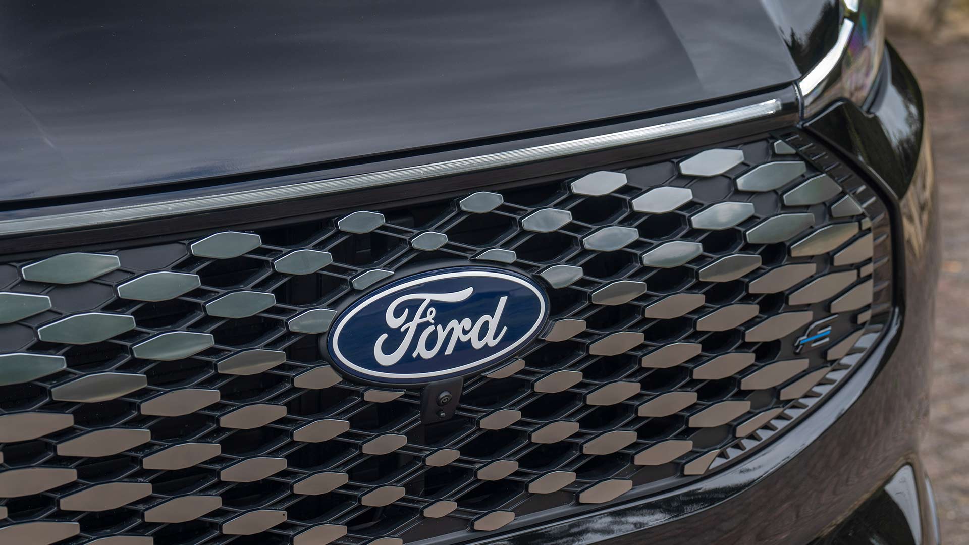 Close-up of the Ford logo and patterned grille on Ford E-Tourneo Custom.