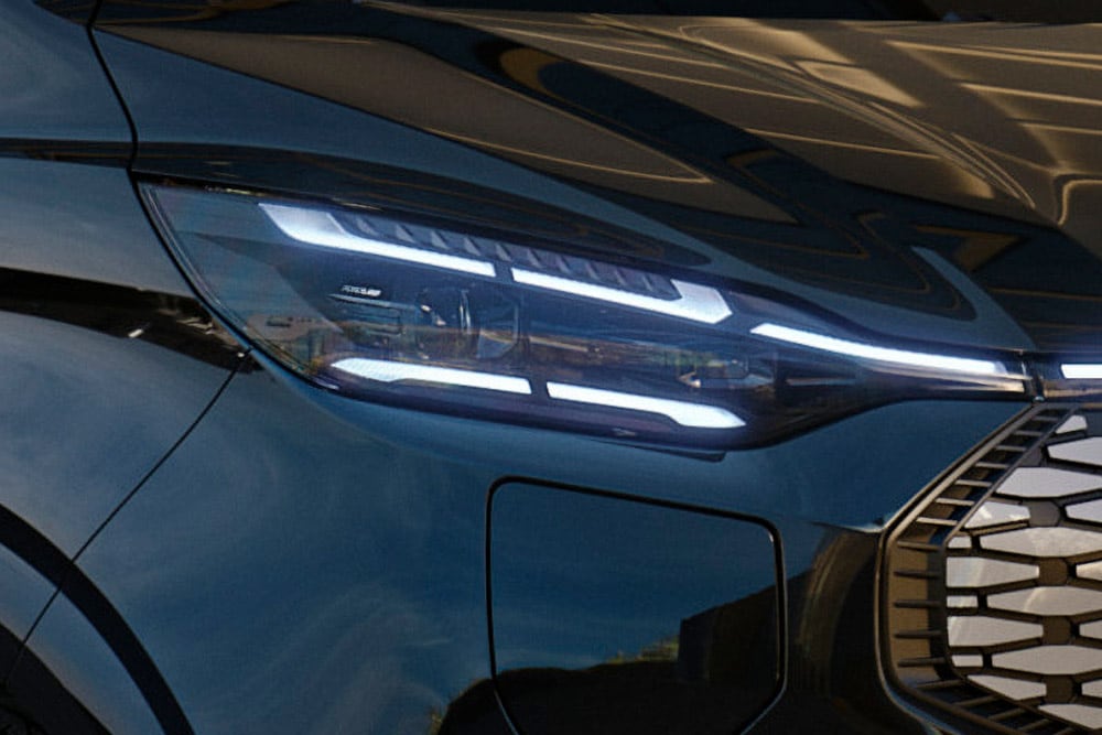 Close-up of the Ford Tourneo Custom's LED headlight assembly illuminated.