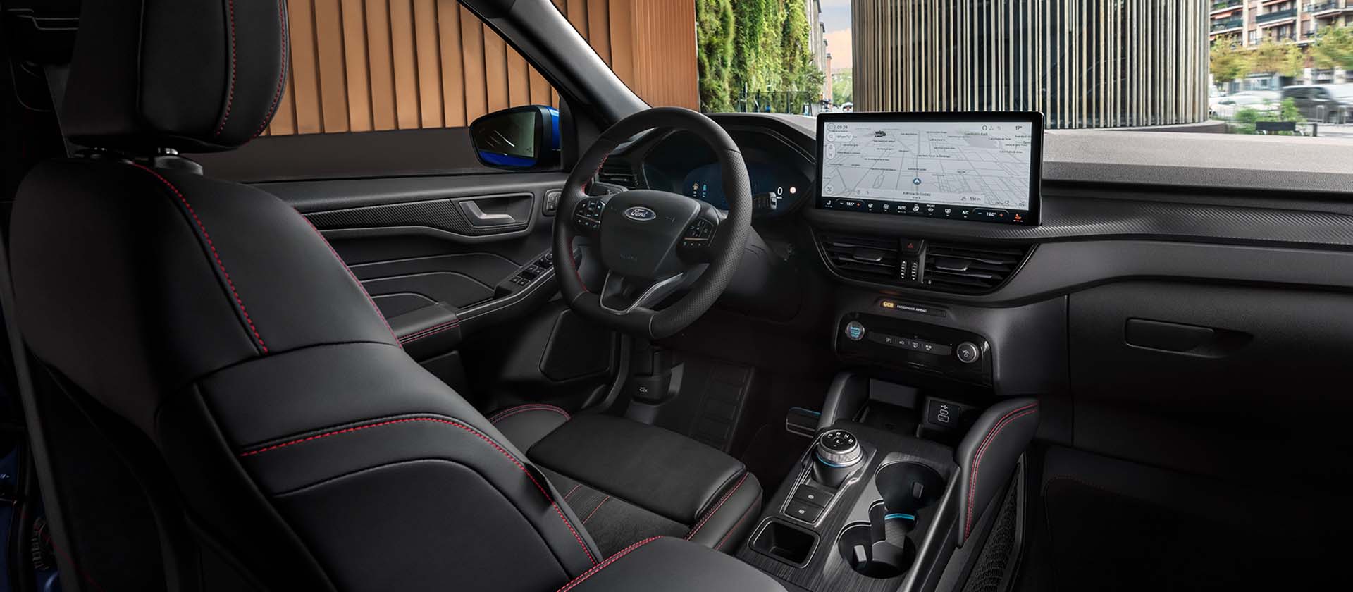Interior of a Ford Kuga, showing the dashboard, steering wheel, and large central touchscreen.