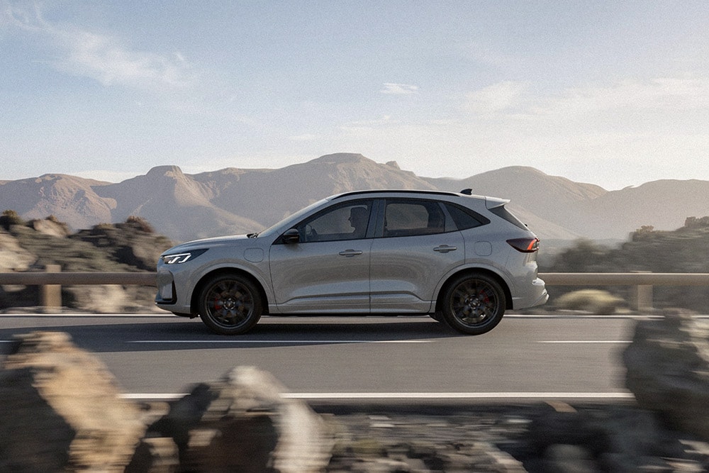 Silver Ford Kuga driving along a scenic mountainous route. 