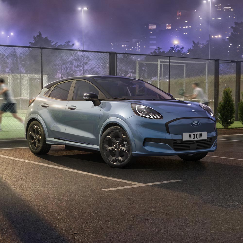 A limited edition Vapour Blue Puma Gen-E parked on a dimly lit city road at night.
