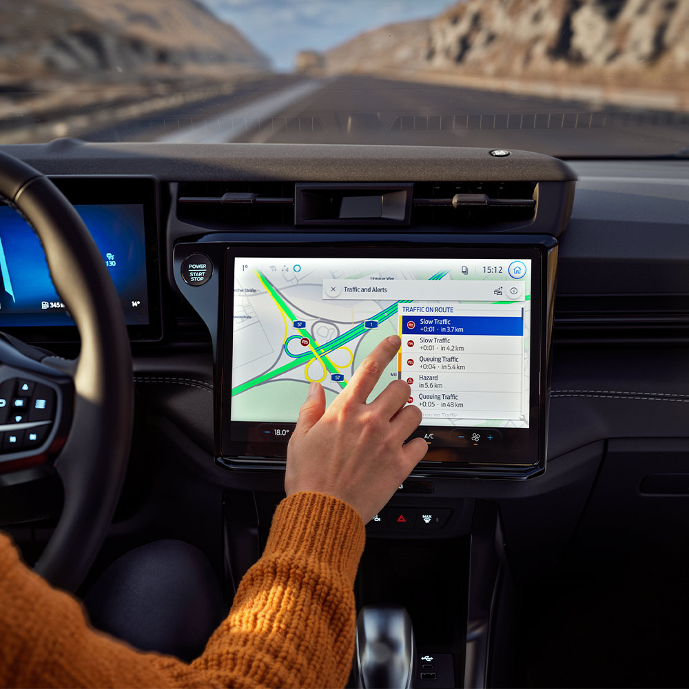 A driver using the Connected Navigation feature on the digital screen in a Ford Puma BlueCruise Edition.
