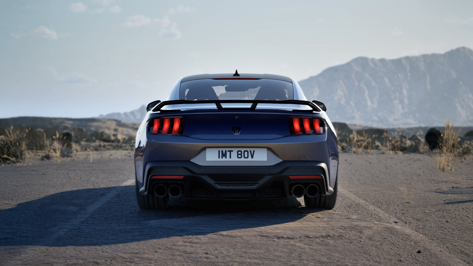 The rear of a Ford Mustang Dark Horse Fastback in Blue Ember paint parked on a mountain road.