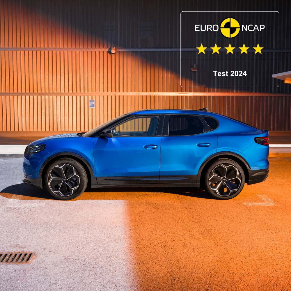 A side view of a blue Ford Capri parked in front of a textured wall. The Euro NCAP 5-star safety rating for 2024 is displayed in the upper right corner.