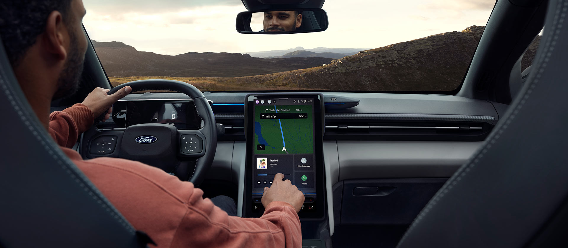 A person driving the electric Ford Explorer on a country road and adjusting the music on the large 14.6" SYNC Move touchscreen.