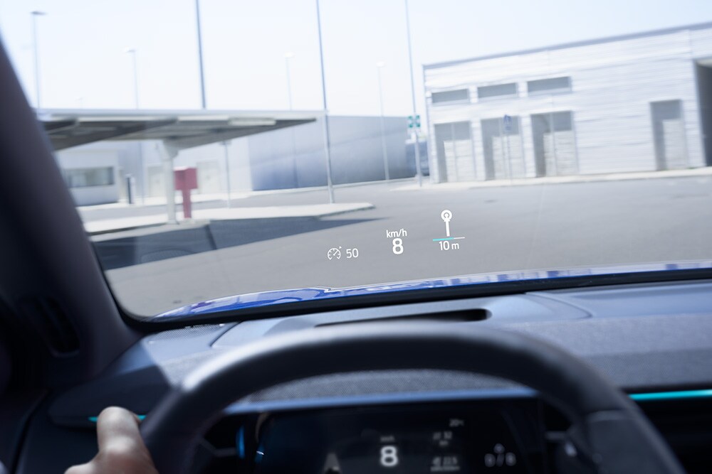 Inside of a Ford vehicle, with a close up of the steering wheel and view outside the dashboard window.