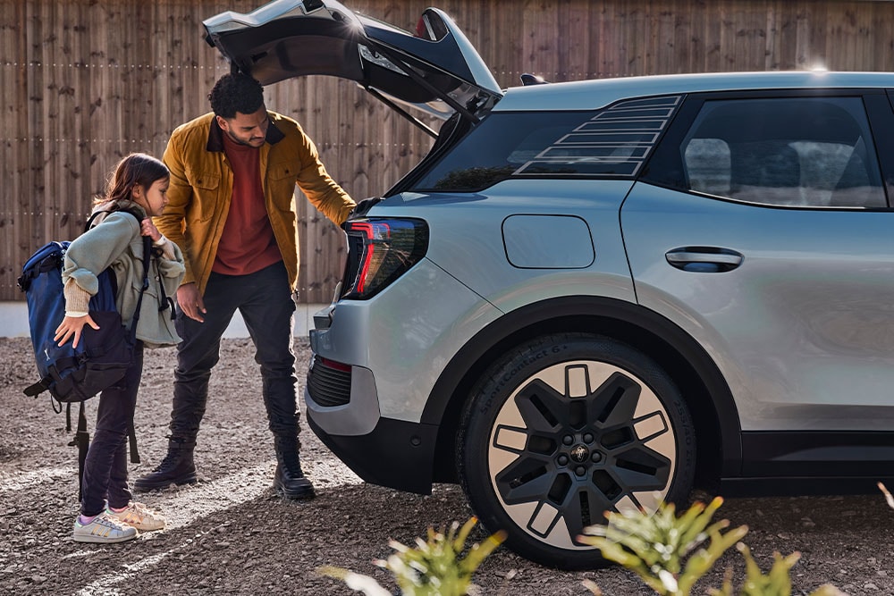 A father and daughter loading the boot of a silver Ford Explorer®.