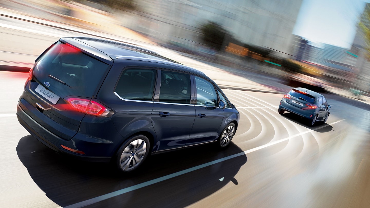 Black Ford Galaxy cruising in town and showing pre-collision assist