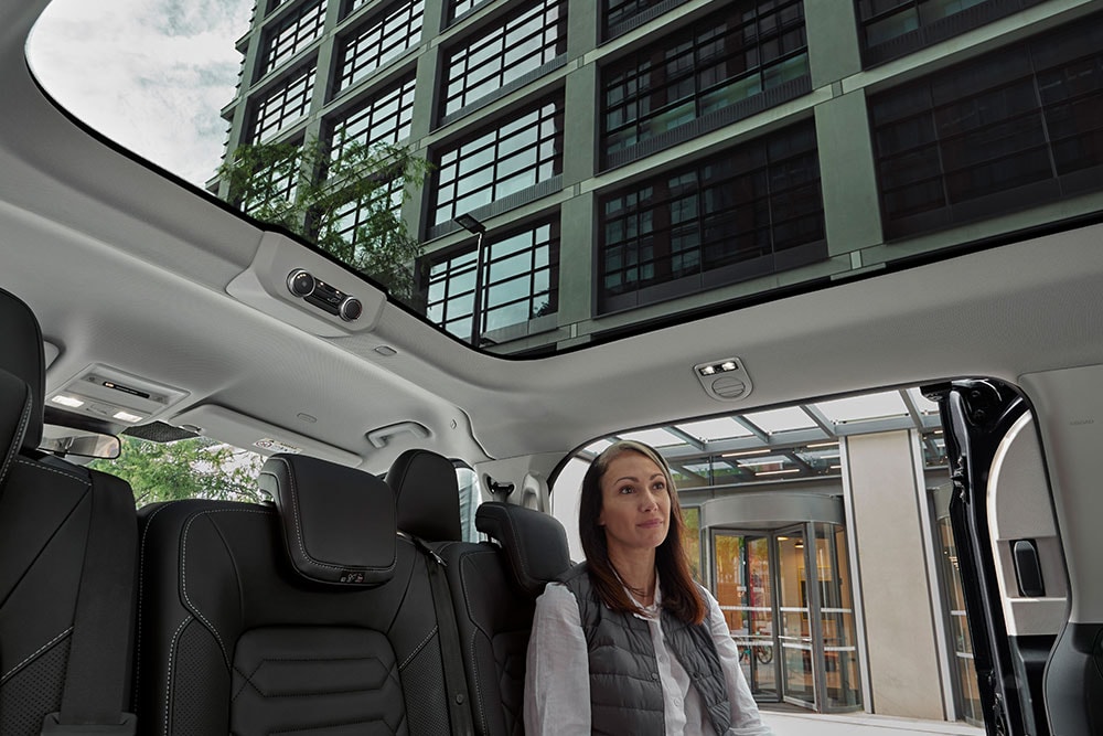 Person looking up the panorama roof of the Tourneo Custom