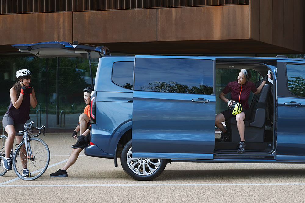 Side view of the Tourneo Custom with peopel around it 