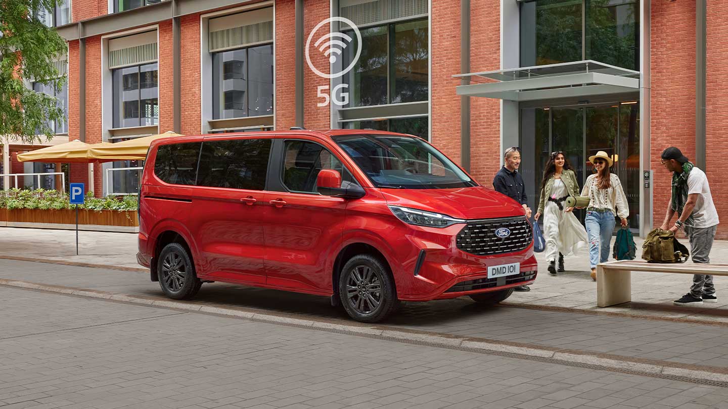 Red Tourneo Custom parked with people around it