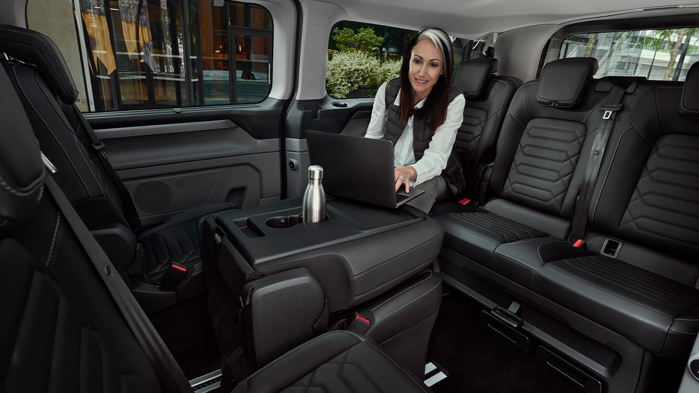 Person using a laptop inside the Tourneo Custom