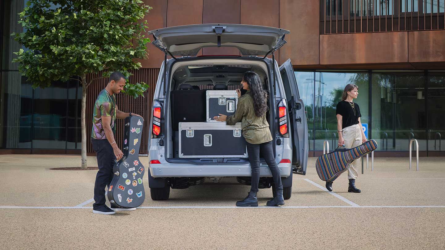 People putting luggage in the back of the Tourneo Custom