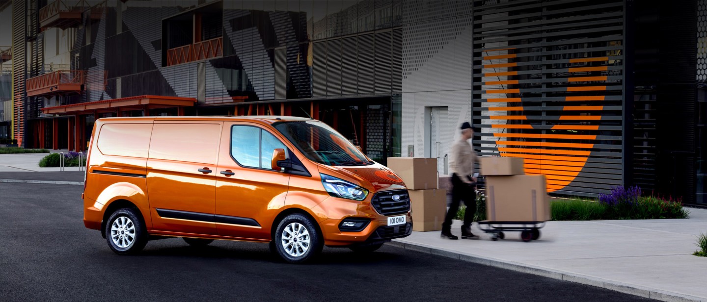 Orange Ford Transit Custom being unloaded in front of the shop