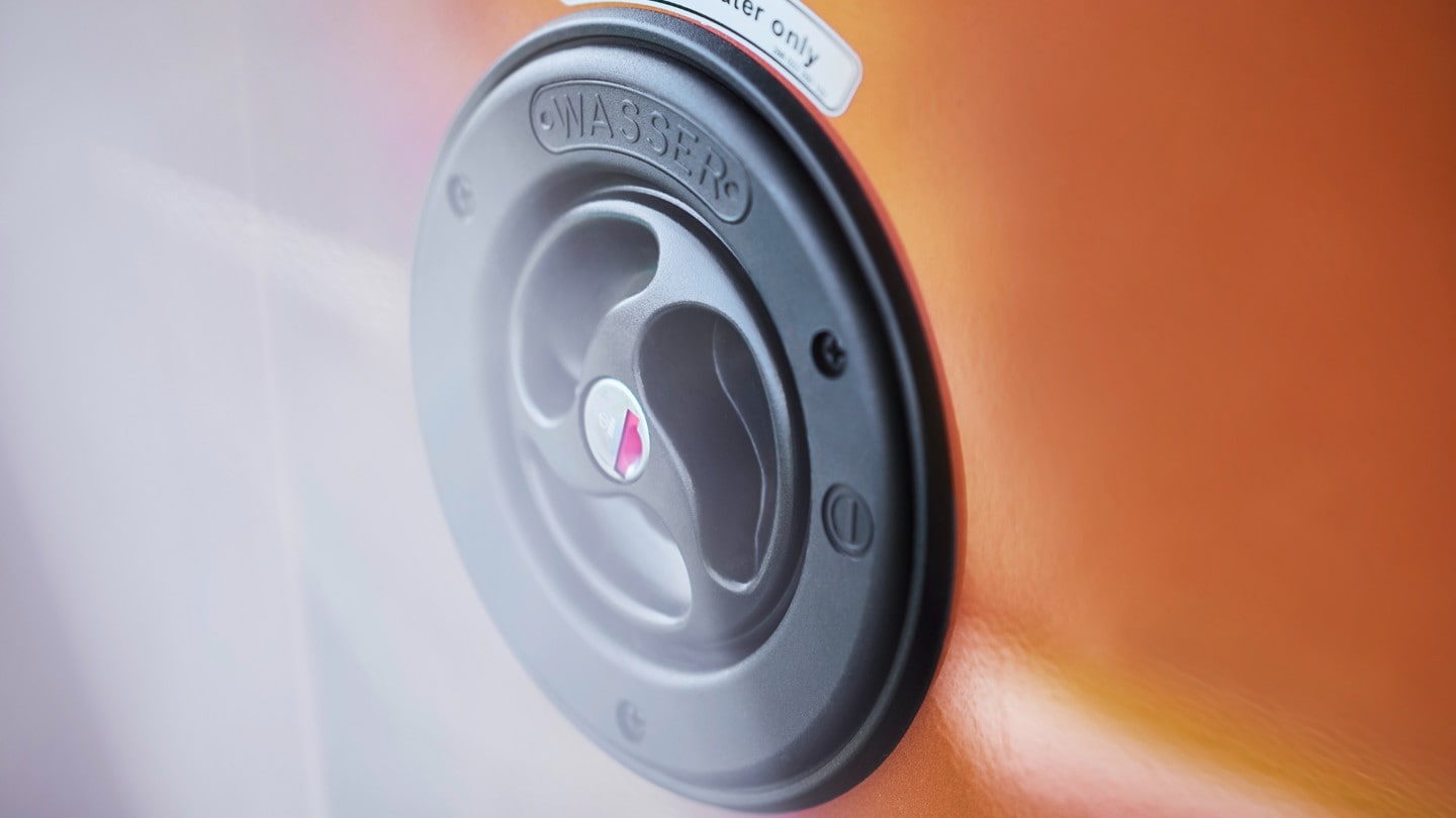 Orange Ford Transit Custom Nugget close up of recharging point Orange Ford Transit Custom Nugget close up of recharging point