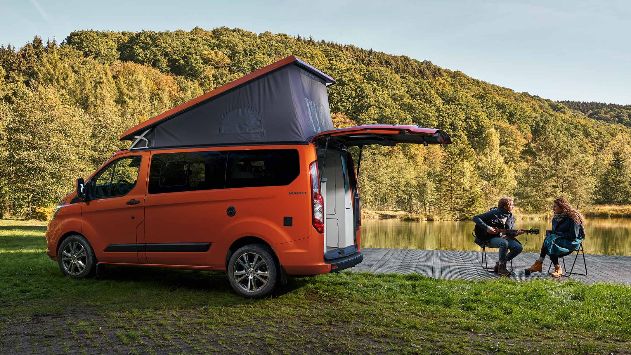Orange Ford Transit Custom Nugget side view with raised roof Orange Ford Transit Custom Nugget side view with raised roof