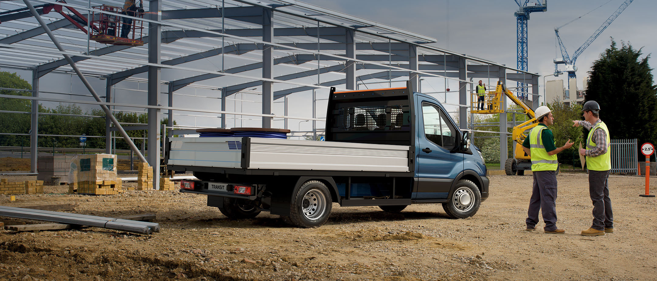 Ford Transit Chassis Cab parked on building site with two workmen in high-viz jackets