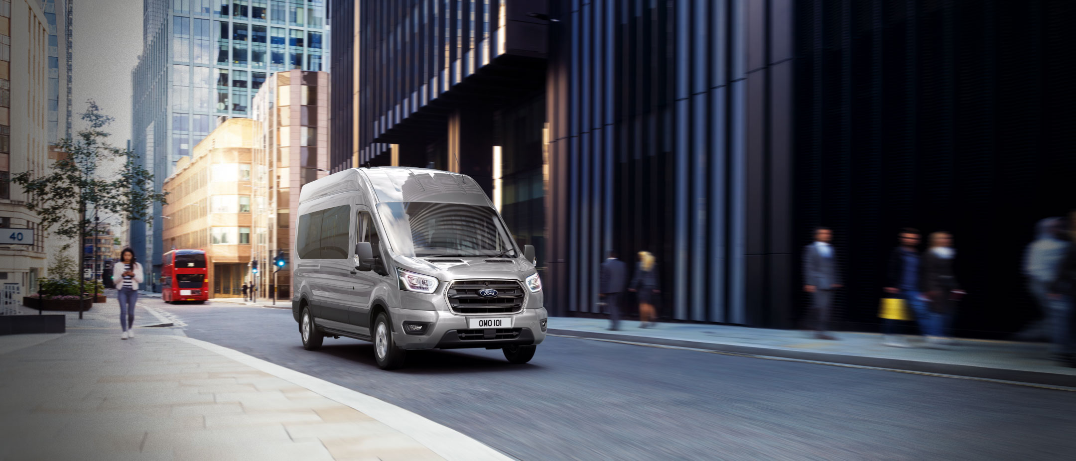 Front view of the Ford Transit Minibus driving on a quiet road in London