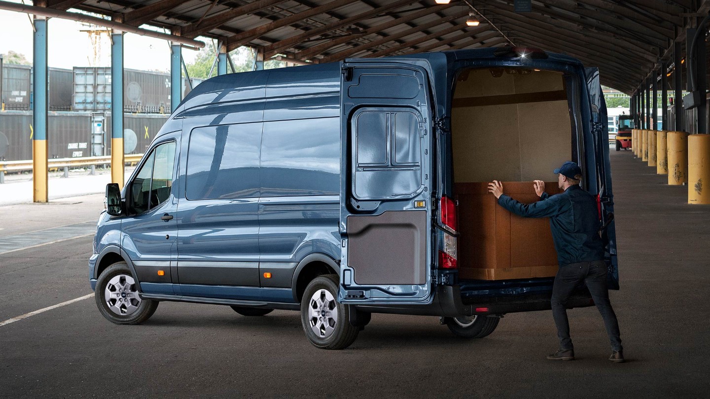 man loading cargo in a Ford Transit Van from rear side