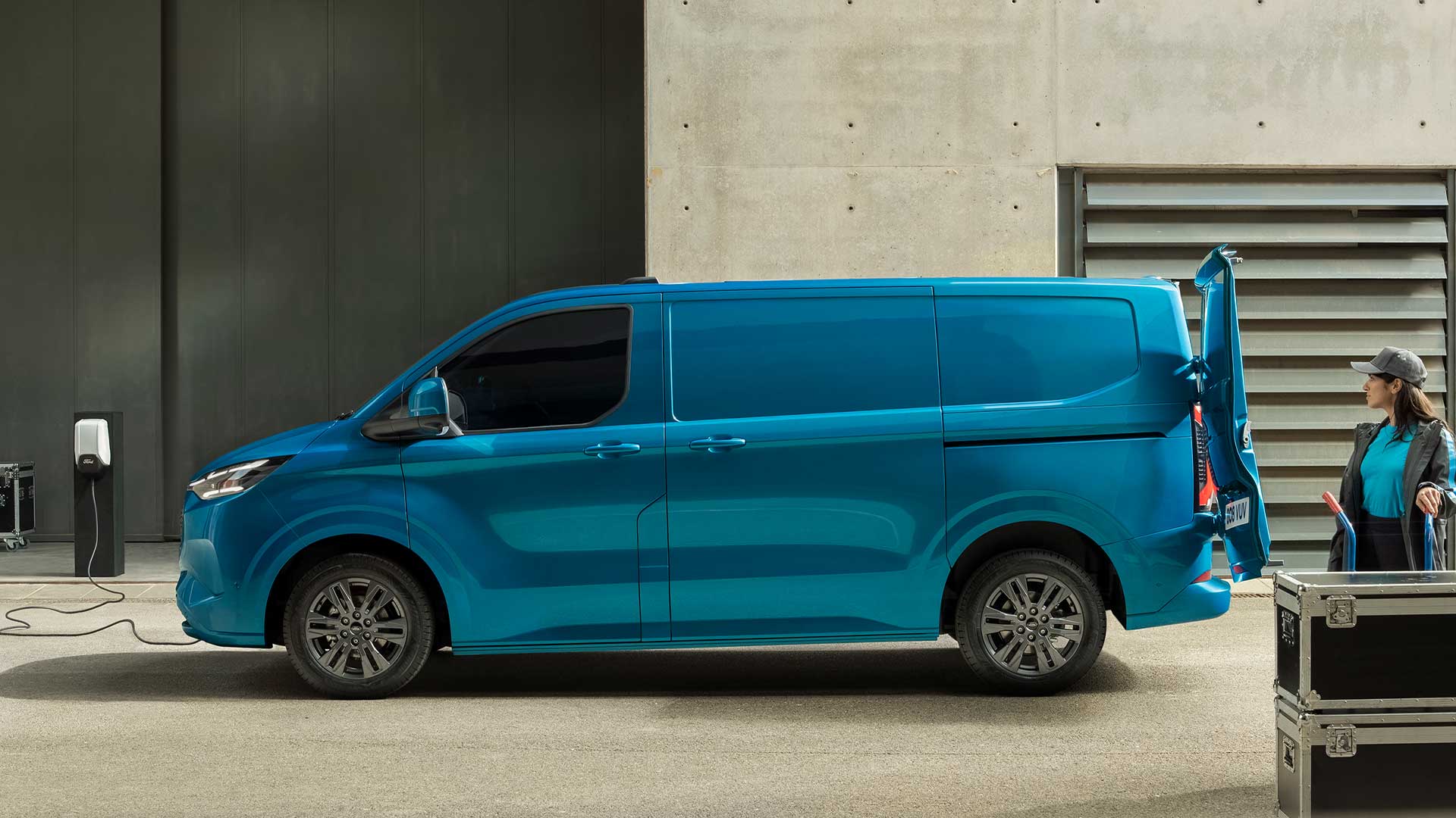 Blue Ford E-Transit Custom electric van charging.