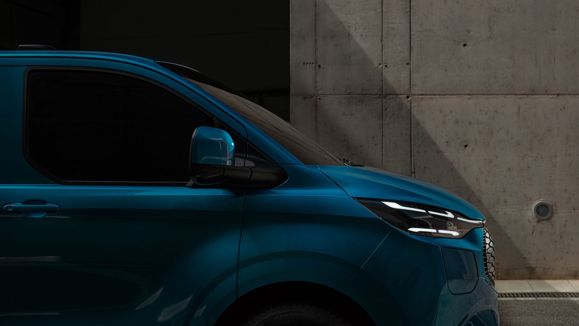 Close-up of blue Ford E-Transit Custom's LED headlight.