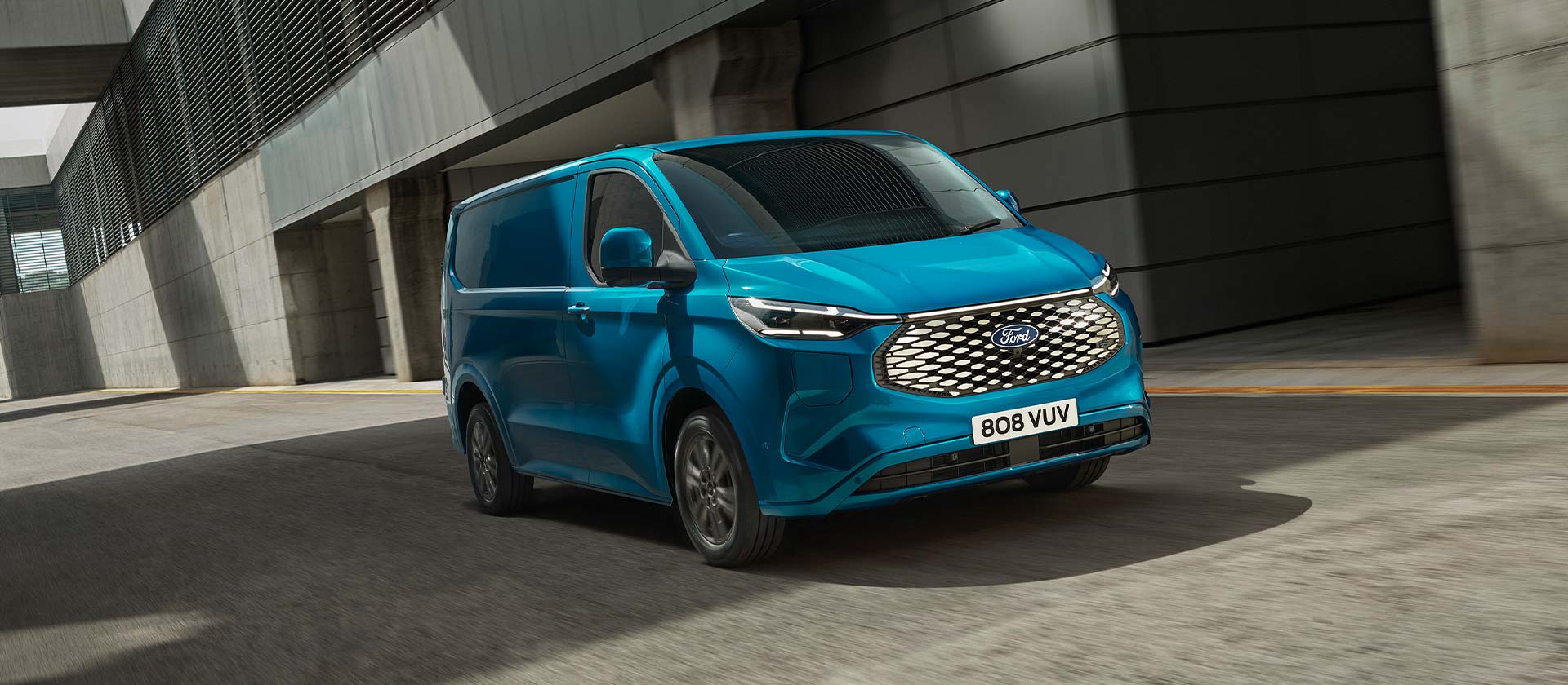 Blue Ford E-Transit Custom electric van, side view.