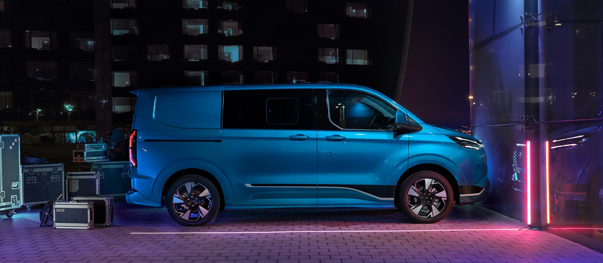 Blue Ford E-Transit Custom electric van, side view.