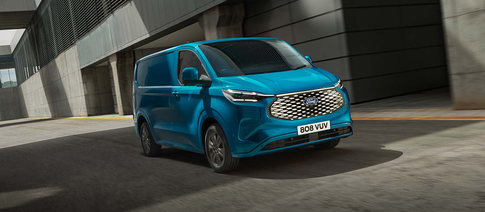Blue Ford E-Transit Custom electric van, side view.