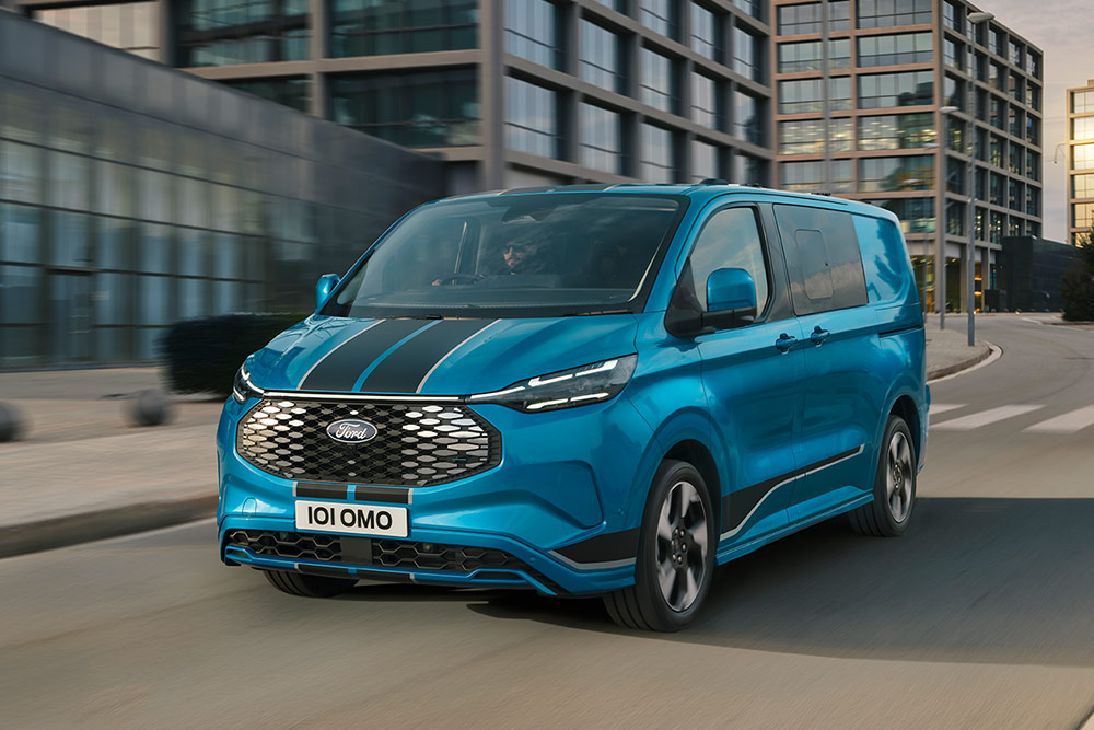 Blue Ford E-Transit Custom Sport Double Cab-in-van driving on a city street.